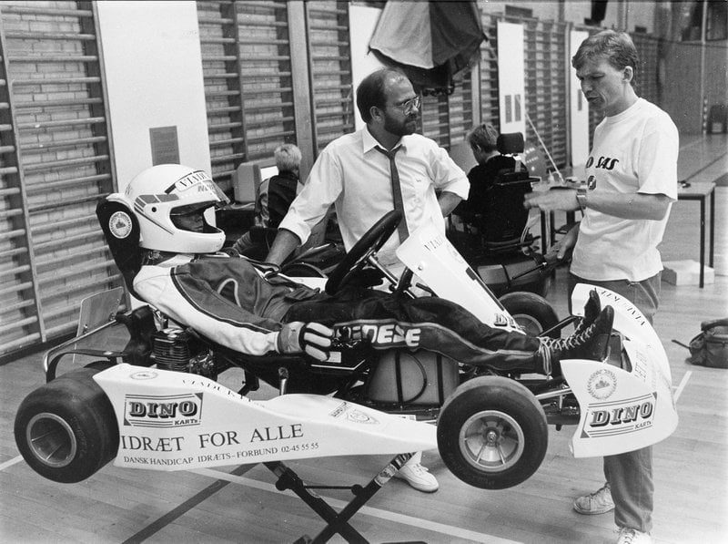 Kristian Jensen (th) fortæller om DHIFs arbejde med at udvikle nye idrætsredskaber til mennesker med svære fysiske handicap og fremviser en prototype af en joystick-styret gocart. Foto fra europæisk workshop i Vingsted, 1988.