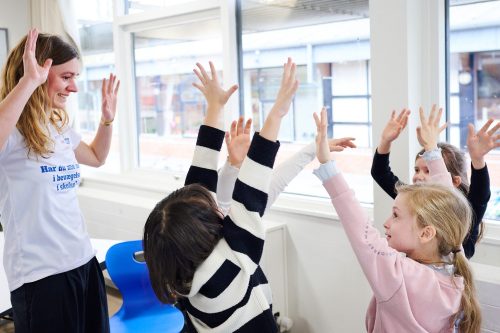 Karla Borup Jonsen og fire børn rækker hænderne op i luften - test af digitalt bevægelsesunivers.